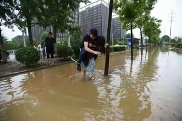 Chine: Elle porte son copain sur son dos pour traverser une rue inondée, sa raison est hilarante!