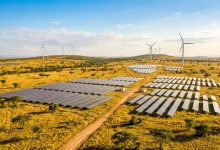 Solar panels and wind turbines on an African savanna landscape
