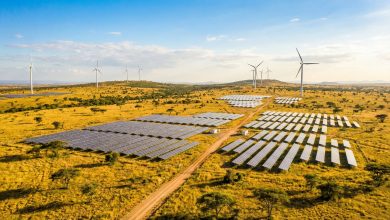 Solar panels and wind turbines on an African savanna landscape