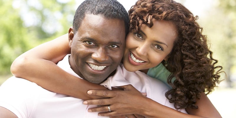 Portrait Of Young Couple Sitting In Park
