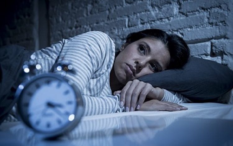 woman in bed late night trying to sleep suffering insomnia