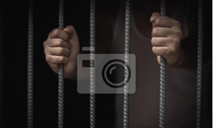 un-homme-entre-des-mains-de-prison-derriere-des-cales-en-acier-des-prisonniers-de-sexe-masculin-ont-ete-severement-mis-a-l-epreuve-dans-une-prison-sombre-emprisonnement-violence-traite-des-etres-h (1)