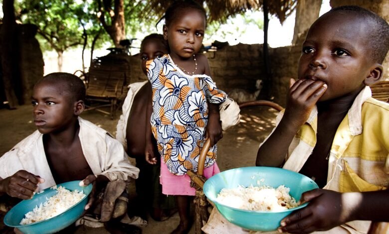 Local children in the village of Kibilo Tougu eating bowls of rice.