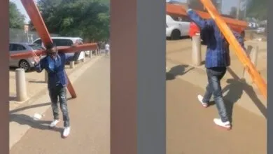 Un pasteur sud-africain porte une grande croix alors qu’il se rend au tribunal pour son procès