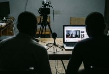 Un studio vidéo sombre avec caméra et ordinateur portable