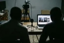 Un studio vidéo sombre avec caméra et ordinateur portable