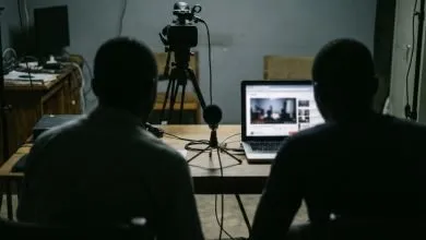 Un studio vidéo sombre avec caméra et ordinateur portable