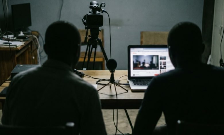 Un studio vidéo sombre avec caméra et ordinateur portable