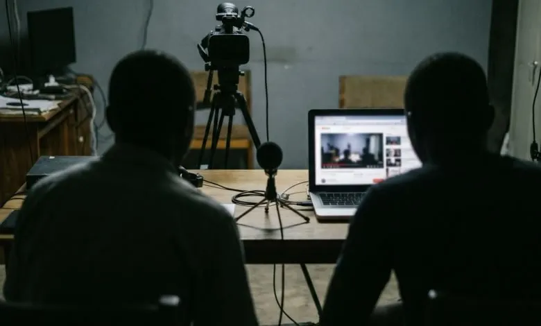 Un studio vidéo sombre avec caméra et ordinateur portable