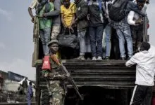 Des hommes montent dans un camion sous la surveillance d’un militaire dans l’est de la RDC