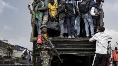 Des hommes montent dans un camion sous la surveillance d’un militaire dans l’est de la RDC
