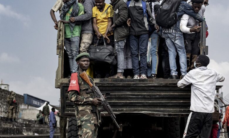Des hommes montent dans un camion sous la surveillance d’un militaire dans l’est de la RDC