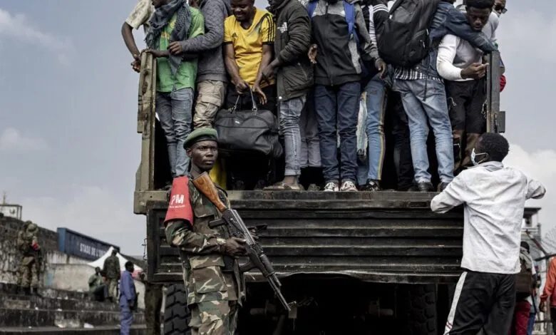 Des hommes montent dans un camion sous la surveillance d’un militaire dans l’est de la RDC