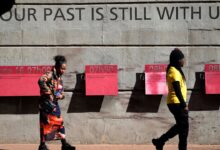 Des visiteurs devant un mémorial du soulèvement de Soweto en Afrique du Sud