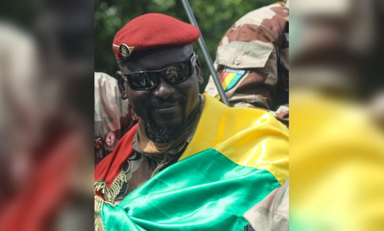 Mamadi Doumbouya portant un béret rouge et le drapeau guinéen