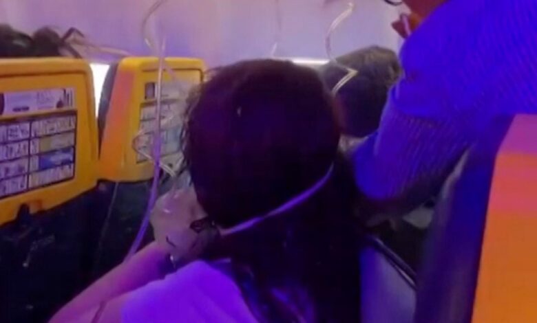 Passagers avec des masques à oxygène dans la cabine du vol Ryanair FR1879