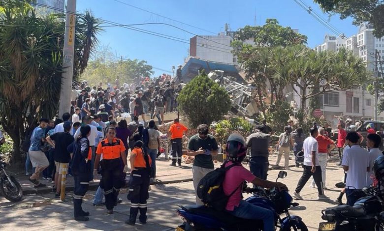 Secouristes et habitants devant un bâtiment effondré après le séisme en Colombie