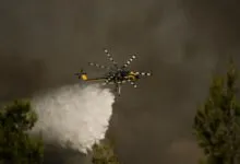 Un hélicoptère largue de l'eau sur un incendie près d'Athènes