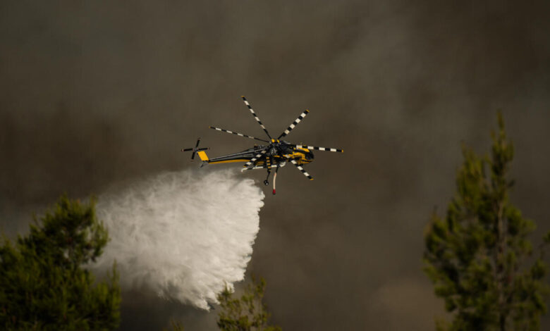 Un hélicoptère largue de l'eau sur un incendie près d'Athènes