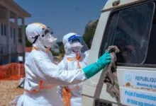 Des agents de santé désinfectent un véhicule pendant la riposte contre Ebola en RDC
