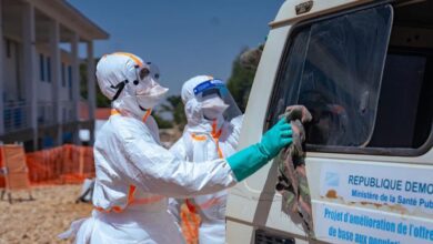 Des agents de santé désinfectent un véhicule pendant la riposte contre Ebola en RDC