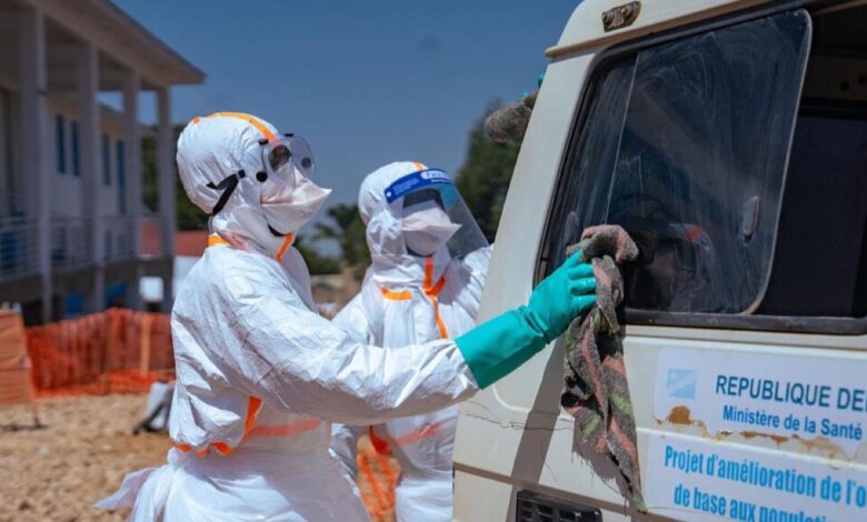 Des agents de santé désinfectent un véhicule pendant la riposte contre Ebola en RDC