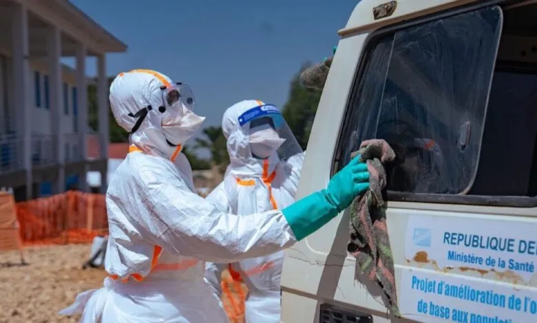 Des agents de santé désinfectent un véhicule pendant la riposte contre Ebola en RDC