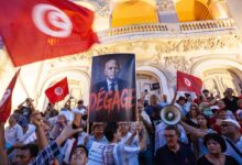 Manifestants à Tunis avec des drapeaux tunisiens et une pancarte visant Kaïs Saïed