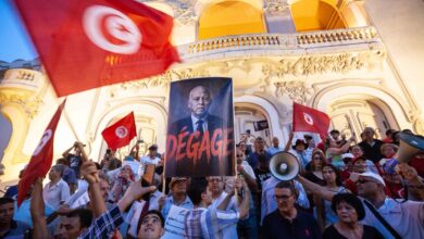 Manifestants à Tunis avec des drapeaux tunisiens et une pancarte visant Kaïs Saïed