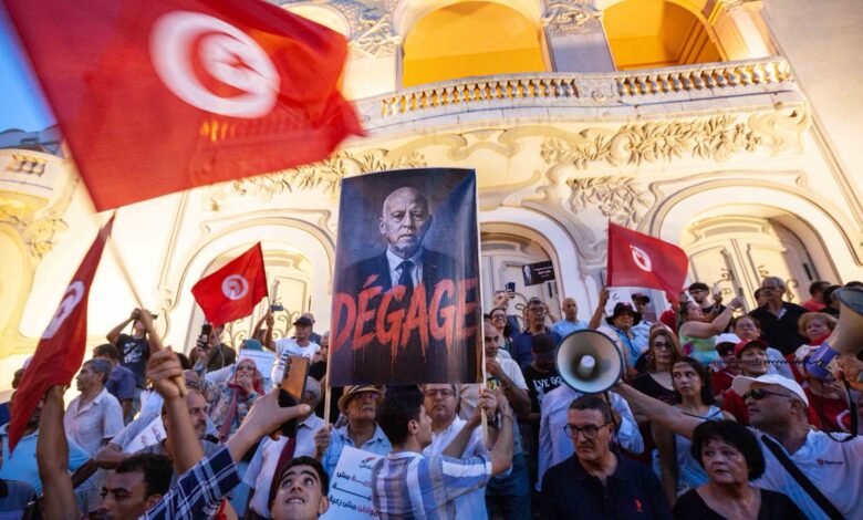 Manifestants à Tunis avec des drapeaux tunisiens et une pancarte visant Kaïs Saïed