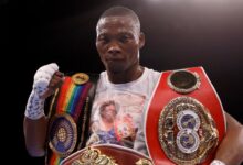 Zolani Tete portant plusieurs ceintures de champion de boxe
