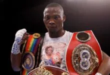 Zolani Tete portant plusieurs ceintures de champion de boxe