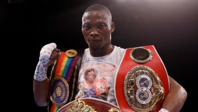 Zolani Tete portant plusieurs ceintures de champion de boxe