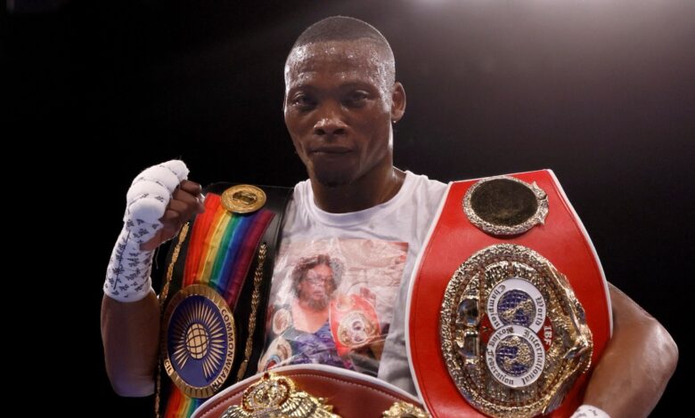 Zolani Tete portant plusieurs ceintures de champion de boxe