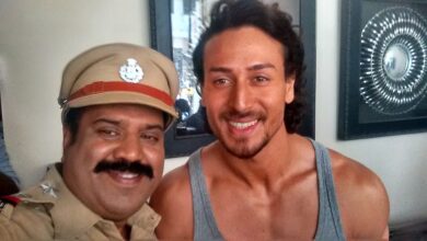Tiger Shroff à droite avec un acteur en costume de policier sur le tournage de Munna Michael