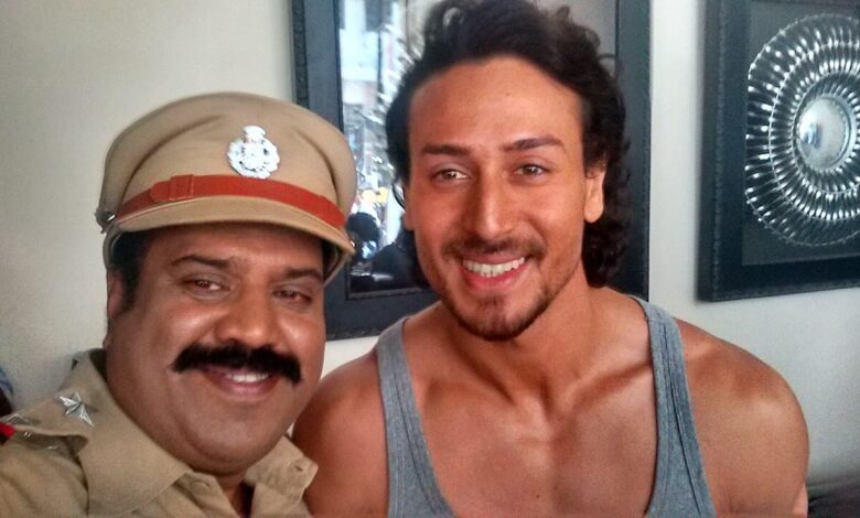 Tiger Shroff à droite avec un acteur en costume de policier sur le tournage de Munna Michael