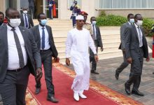Mahamat Idriss Déby en boubou blanc, entouré de collaborateurs et de gardes lors d’une cérémonie au Tchad